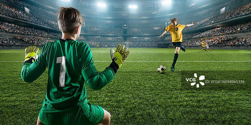 足球儿童球员进球。守门员试图击球图片素材
