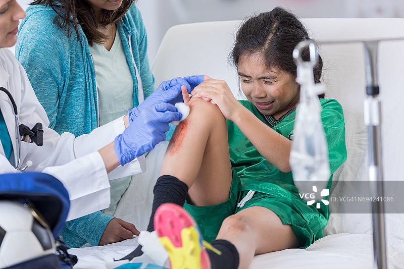 足球运动员腿部受伤，医生进行清理图片素材