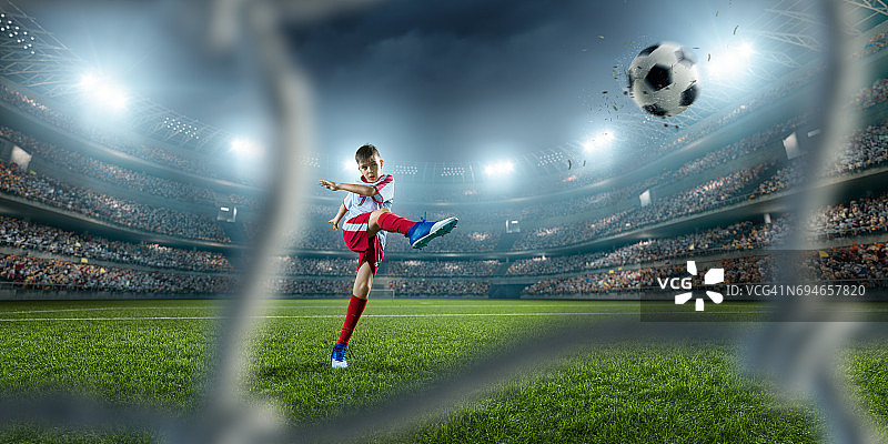 儿童足球运动员射门得分图片素材