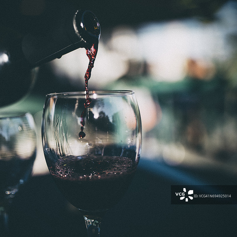 倒入玻璃杯中的红酒特写图片素材