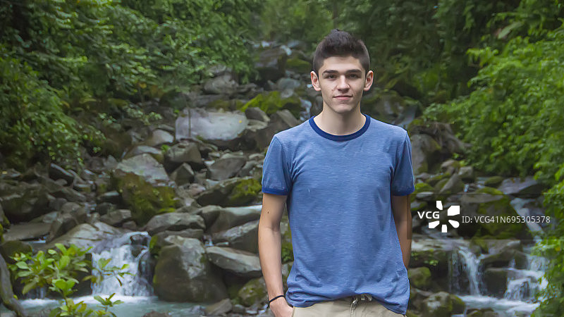 在热带雨林河流前的年轻男人图片素材