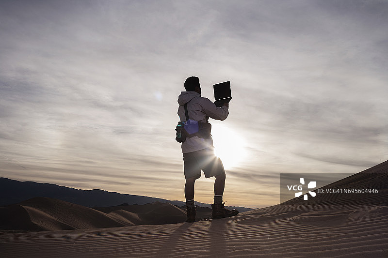 徒步者在沙漠中寻找无线网络图片素材