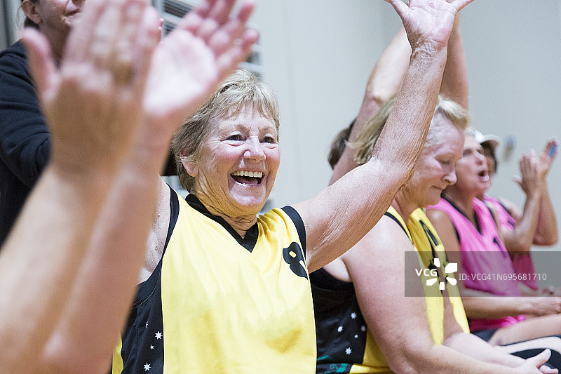 年长的女性团队成员举起双臂庆祝图片素材