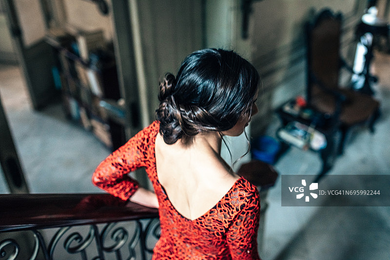 身穿红裙走下老房子楼梯的古巴年轻女人图片素材