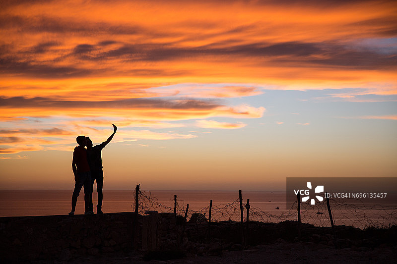 在摩洛哥阿加迪尔观看日落的游客剪影图片素材