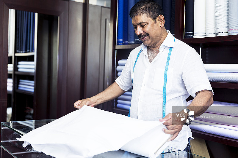 小型商店的成功裁缝展示其优质面料的品质图片素材