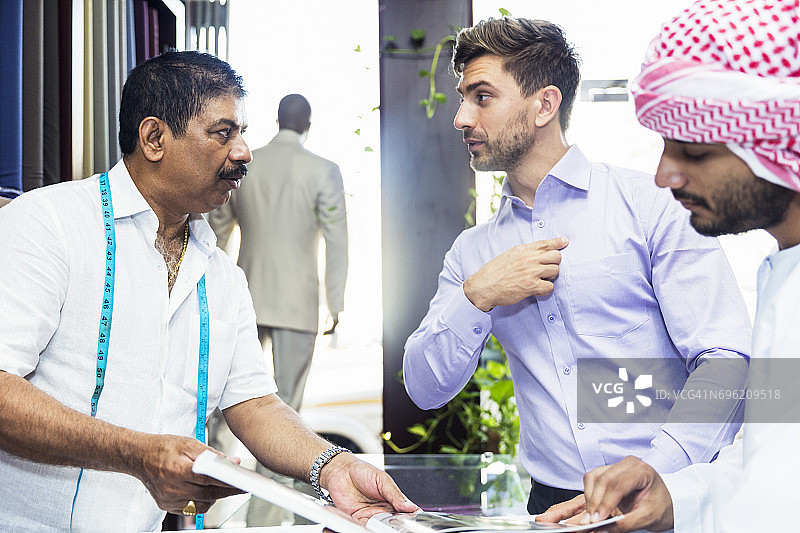 商人比划着要定制合身的西装图片素材