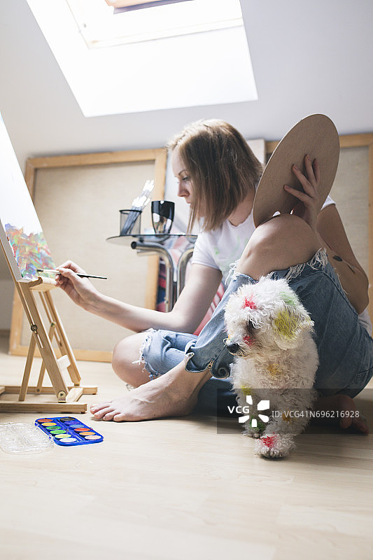 创意绘画：女人和她的狗在工作室里图片素材