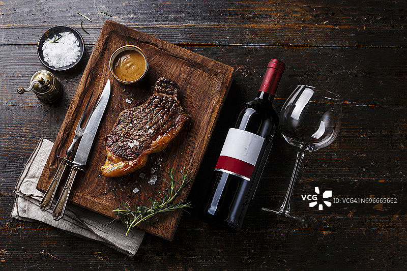 木质背景上的烤牛排和红酒图片素材