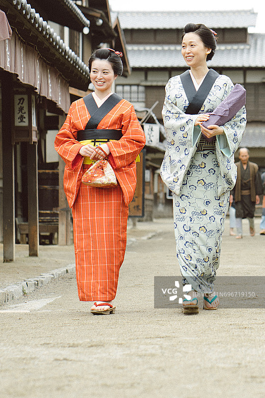 江户时代，穿着和服的日本女子在古老的村庄里散步图片素材
