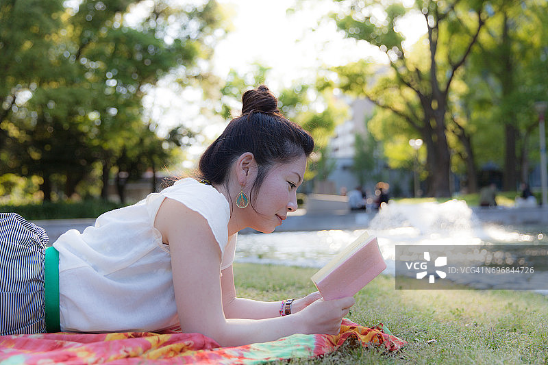 在公园里读书的日本女人图片素材