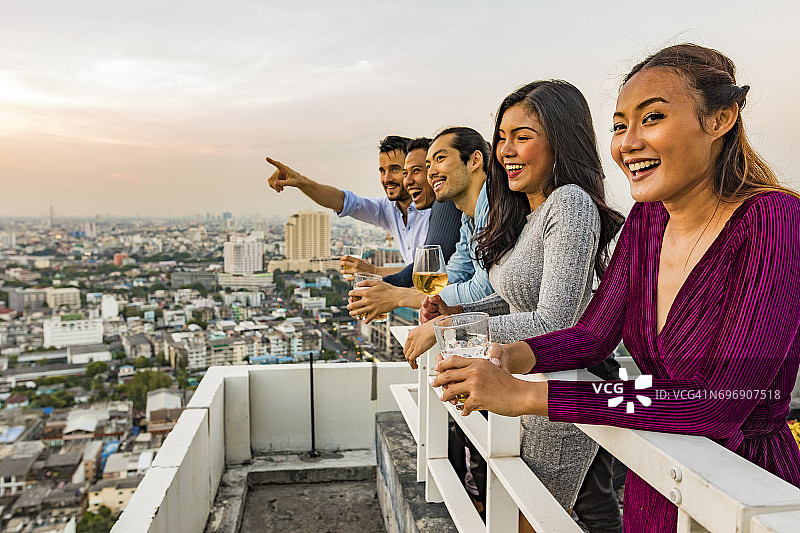多民族朋友在屋顶享受日落饮品图片素材