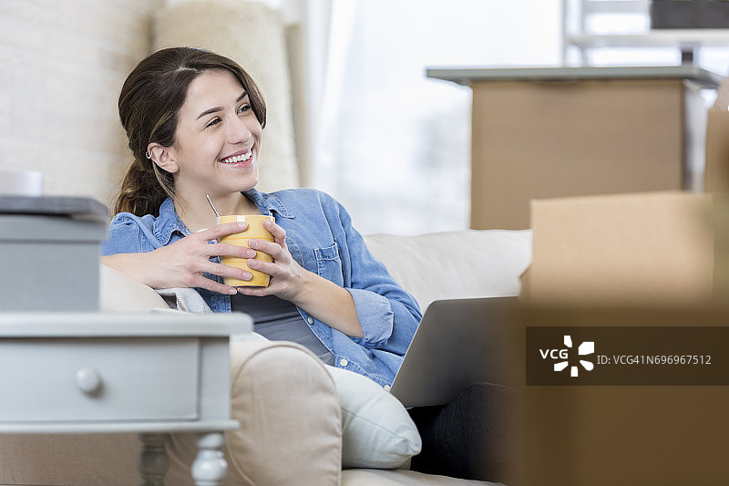 搬家后享受咖啡的年轻女人图片素材