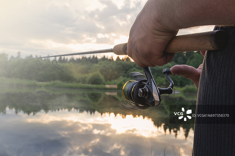 男人在水库里用钓竿钓鱼图片素材