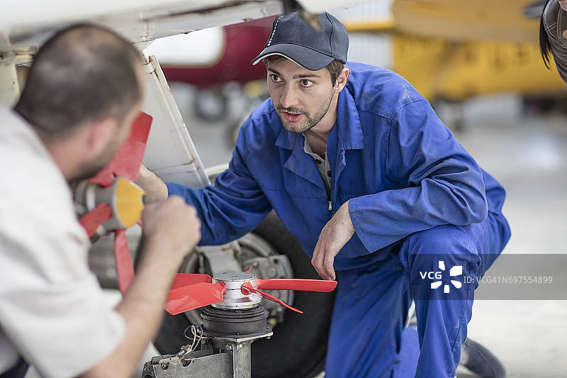 机库中的机械师修理轻型飞机图片素材
