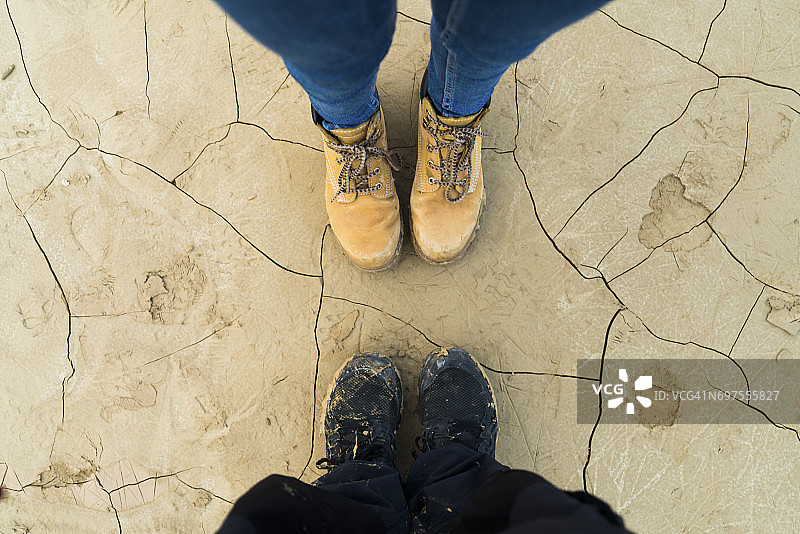 一对夫妇站在干裂地面上的脚图片素材
