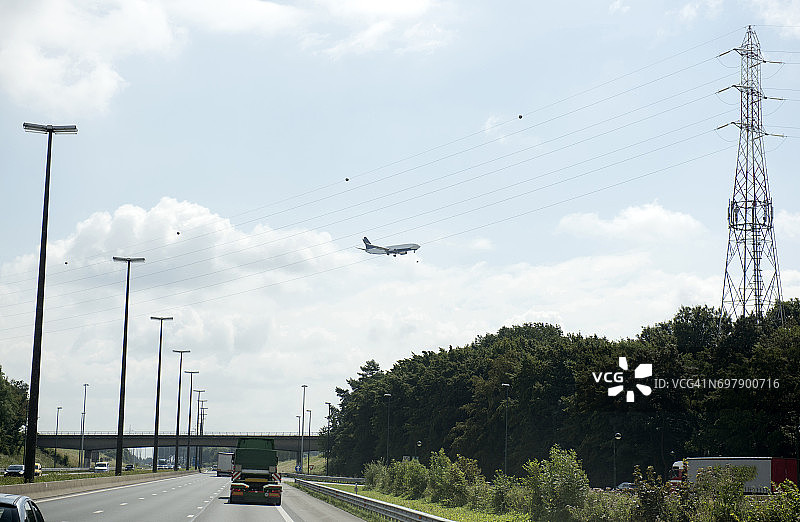 飞机飞过比利时瓦隆大区沙勒罗瓦附近的高速公路图片素材