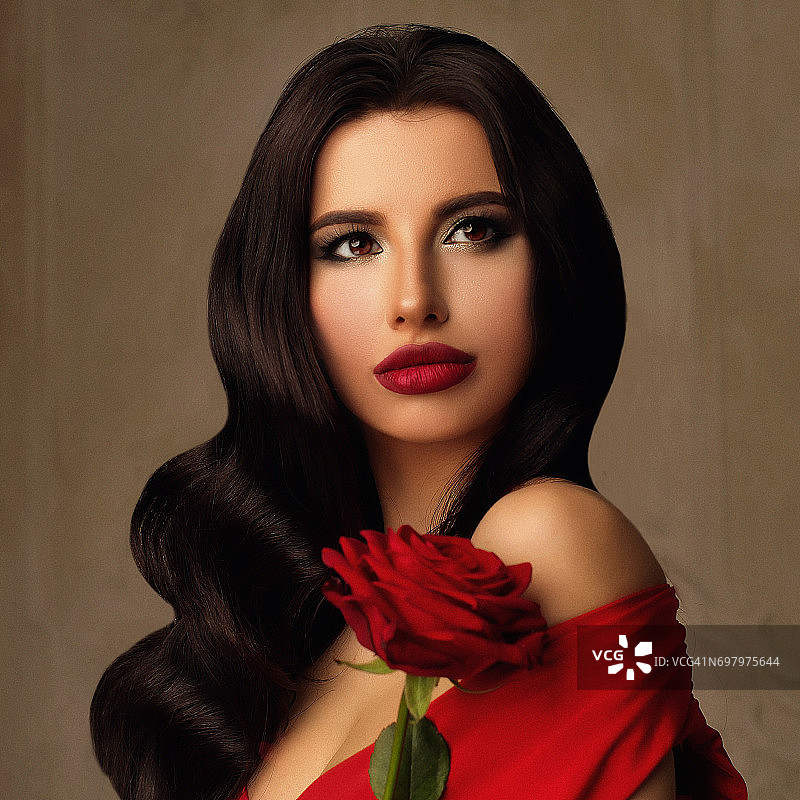 美丽模特的时尚人像。带有好莱坞波浪发型的长而黑亮丽的头发。化着妆、戴着玫瑰花的性感女人图片素材