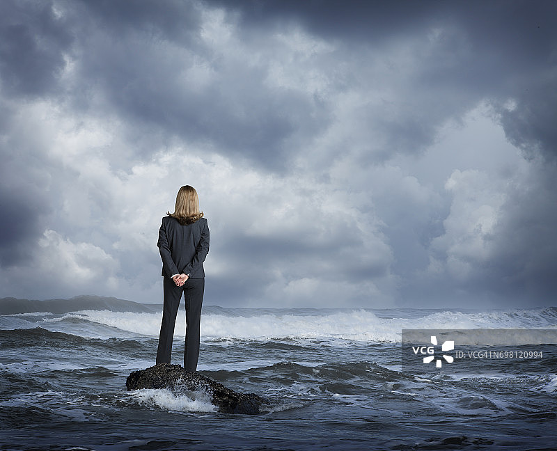 站在汹涌海浪中的女商人图片素材
