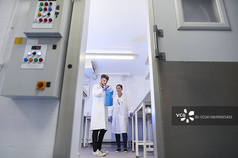 透过门框看实验室里的科学家图片素材