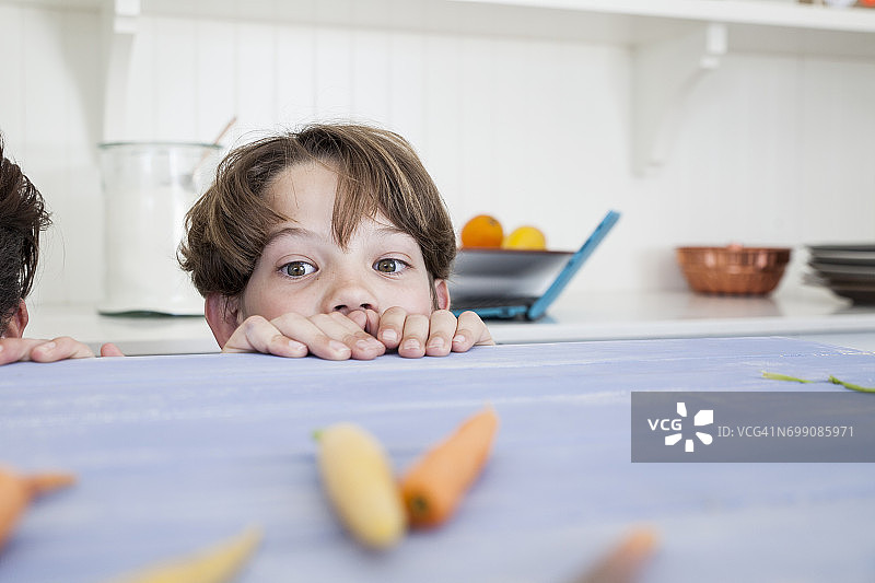 小男孩越过厨房台面图片素材