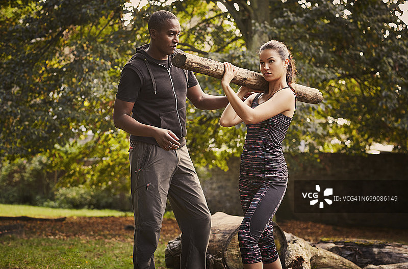 在公园里，私人教练指导女人进行树干肩部提升图片素材