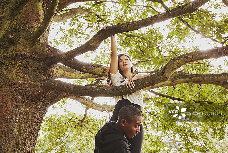 私人教练辅助女性爬树图片素材