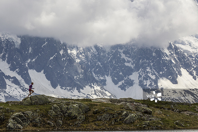 女孩在霞慕尼 Chesery 湖周围进行越野跑图片素材