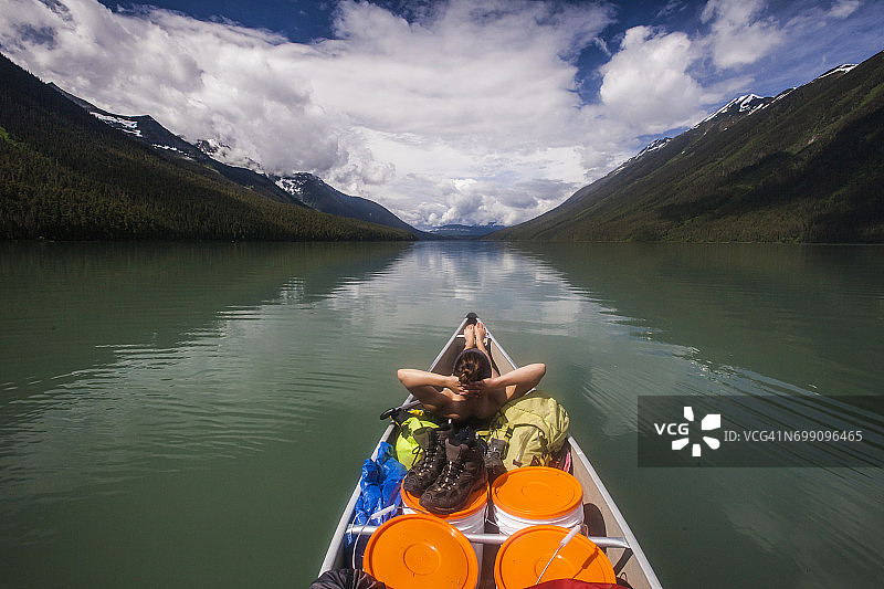 年轻人在独木舟前放松身心，在拉内齐湖上划独木舟图片素材