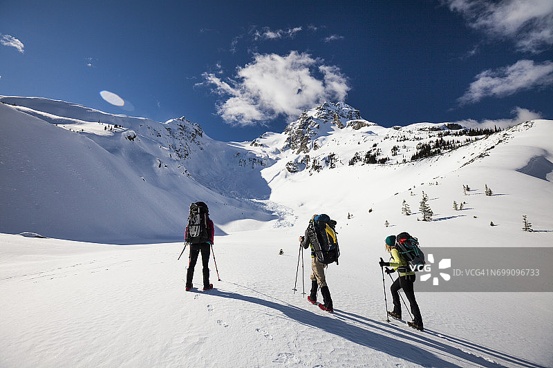 三名登山者前往加拿大不列颠哥伦比亚省的乔弗雷峰顶图片素材