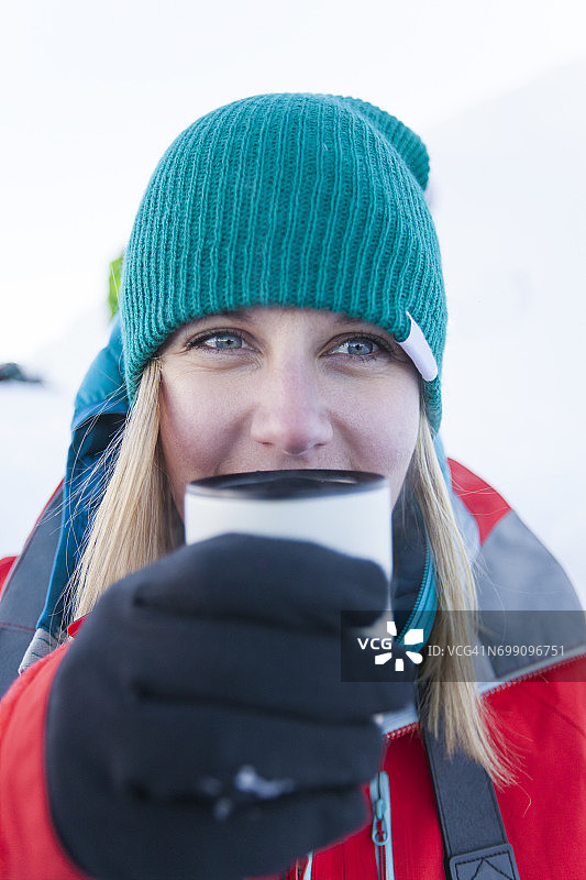 一位年轻的活力女性在冬季露营旅行中享用热饮图片素材