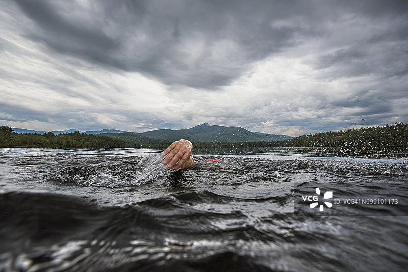 游泳者在湖中划水的手部特写图片素材