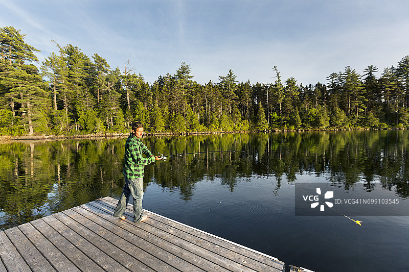 男子在缅因州格林维尔附近的长池塘钓鱼图片素材