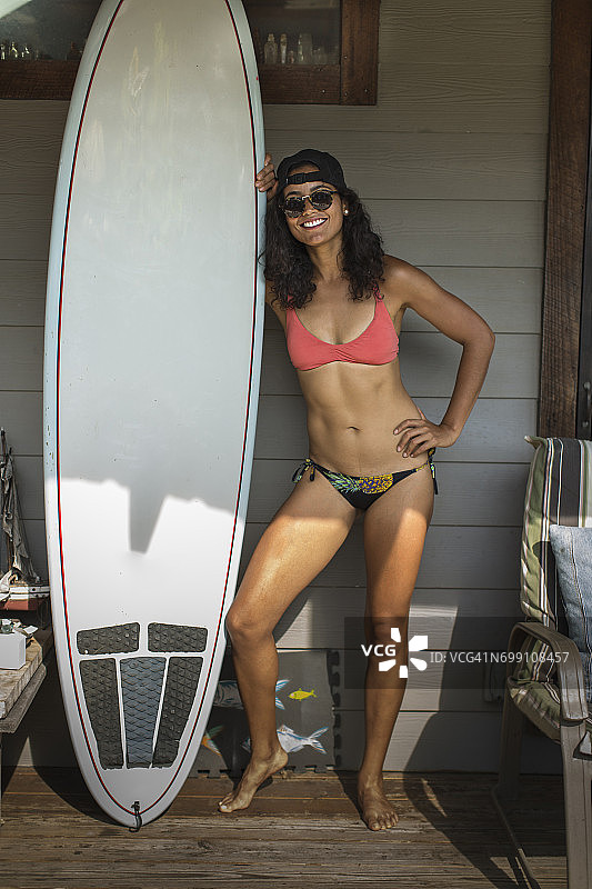 站在门廊上的年轻冲浪女性肖像，美国纽约州洛克威海滩图片素材