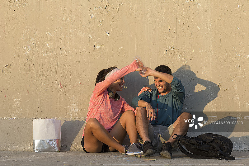 情侣在水泥墙前玩耍图片素材