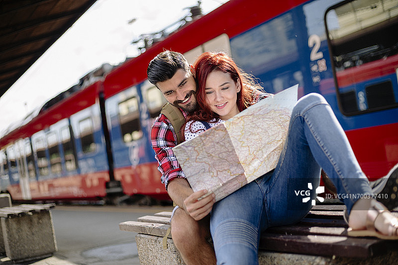年轻夫妇在火车站看地图图片素材