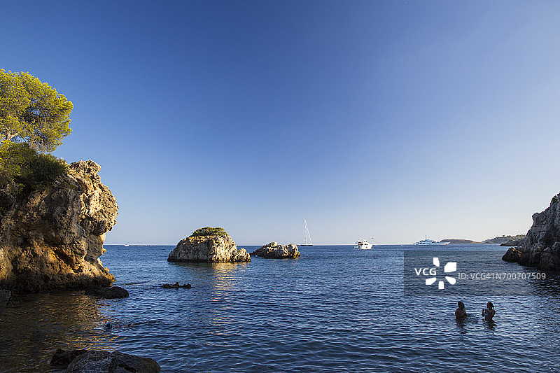 在西班牙马略卡岛卡尔维亚的布拉内斯海岸蓝色大海中游泳的两名游客图片素材
