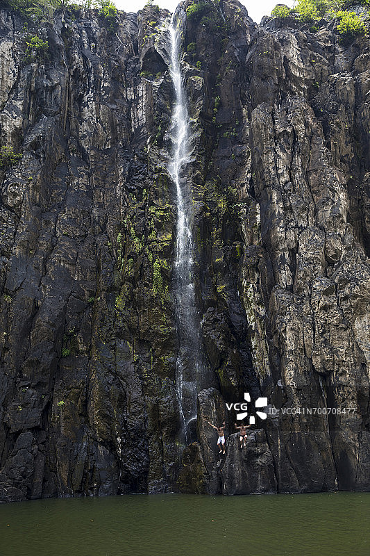留尼汪岛：在瀑布后跳入水中的两人图片素材