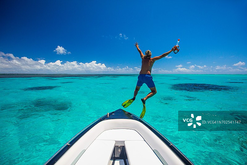 戴着脚蹼从船上跳下的中年男人，毛里求斯图片素材