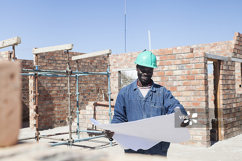 建筑工人在建筑工地上看蓝图图片素材