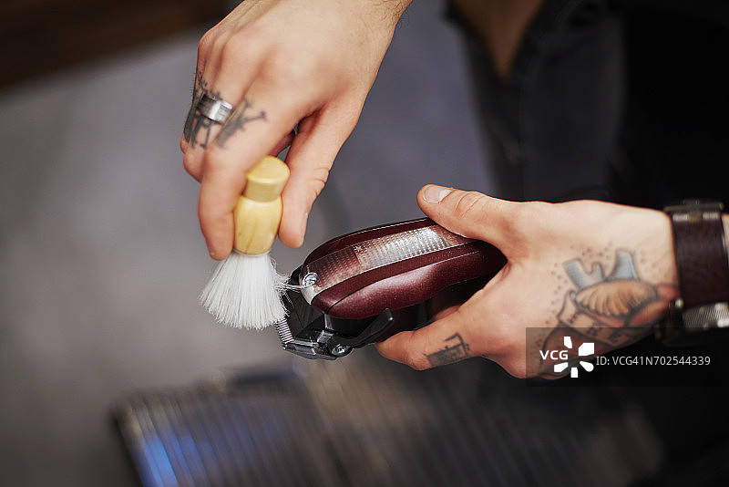 男人用剃须刷清洁电动剃须刀图片素材