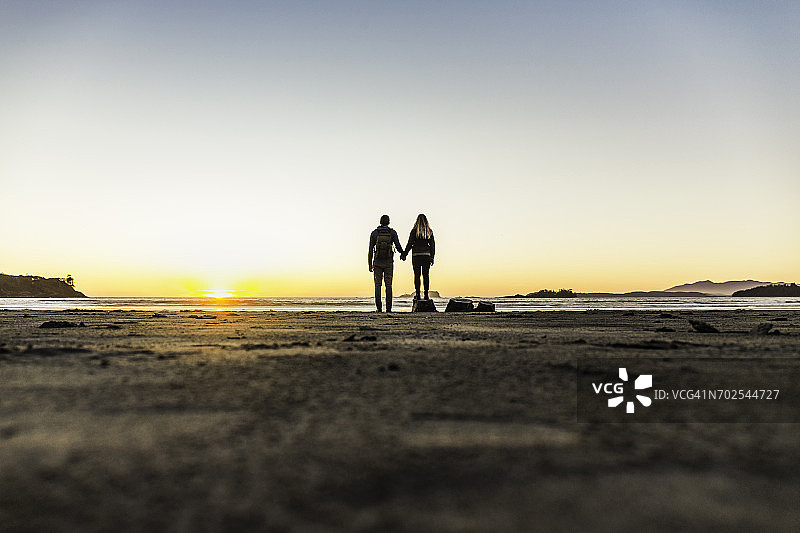 情侣在加拿大不列颠哥伦比亚省温哥华岛的太平洋沿岸国家公园长滩观看日落图片素材