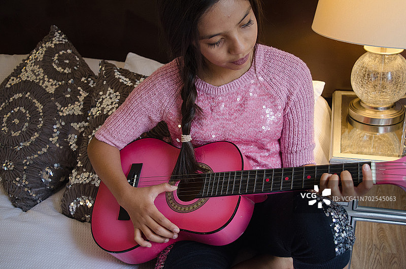 在家弹吉他的年轻女孩图片素材
