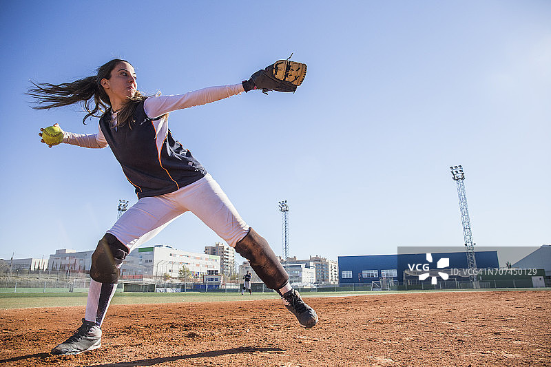 女棒球运动员在棒球比赛中投球图片素材