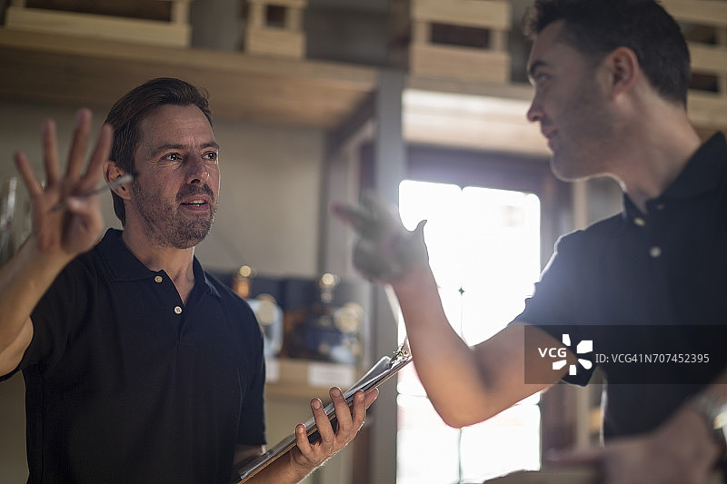 两个男人在仓库里讨论图片素材