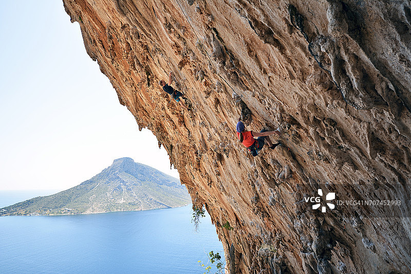 希腊卡林诺斯岛：攀岩者攀登岩壁图片素材