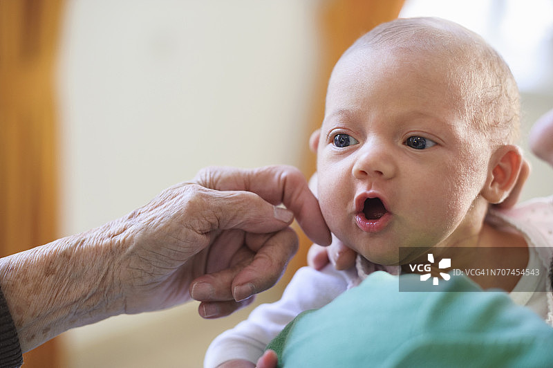 抚摸曾孙女脸颊的老妇人图片素材
