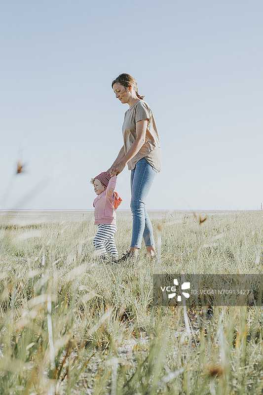 荷兰斯希蒙尼克岛：母亲和女儿在草地上散步图片素材