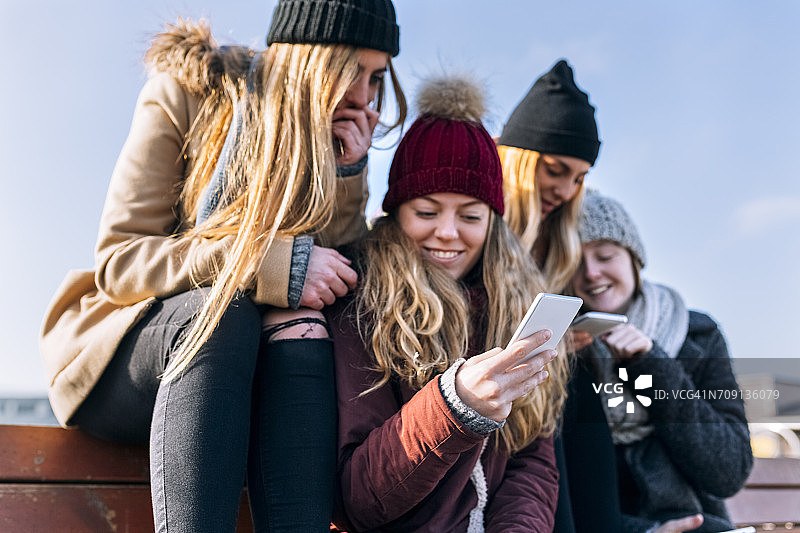 四个朋友在看手机图片素材