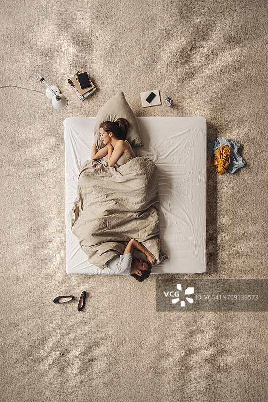 情侣在床上各睡一头，俯视图图片素材